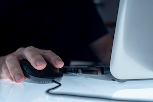 Close up of a hand using a computer mouse.